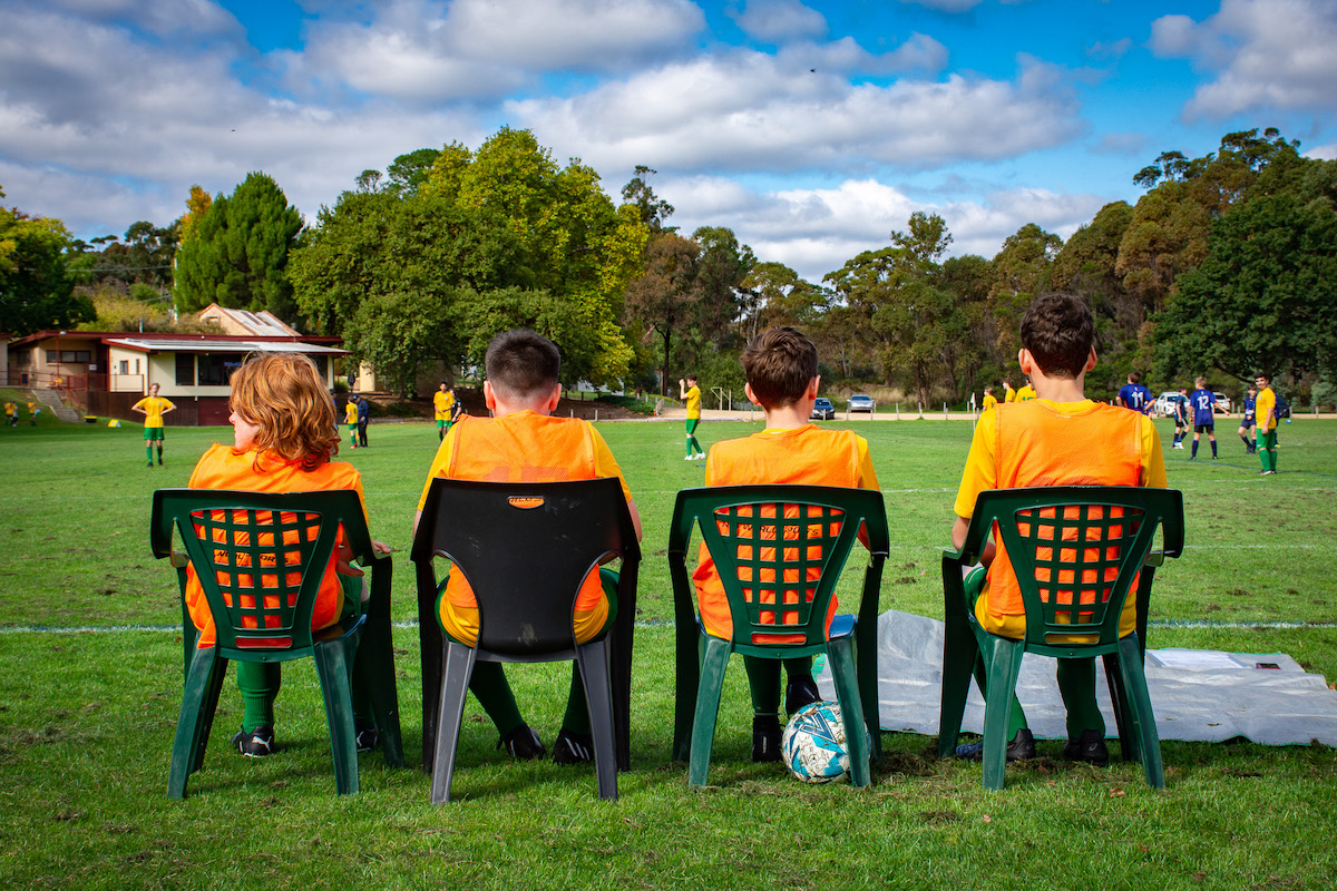 Photo of four people watching a soccer match.